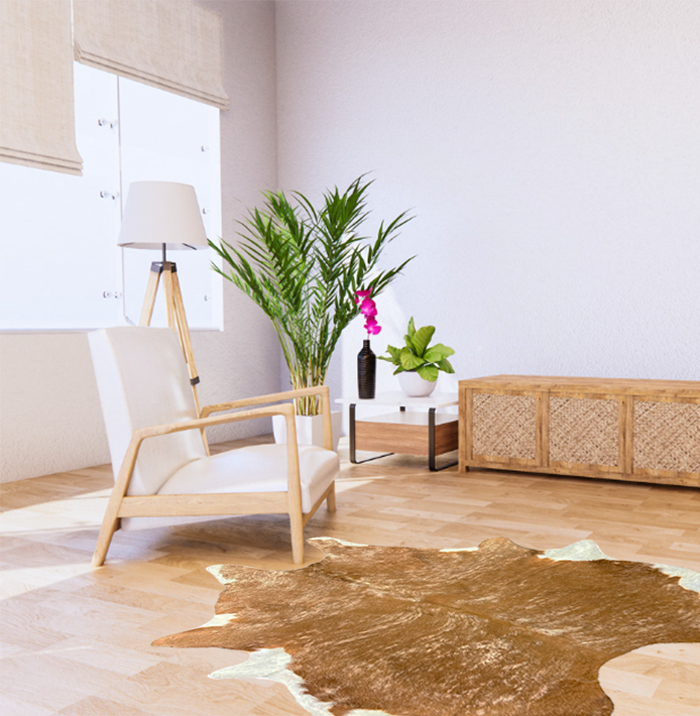 XL Gold Brindle Cowhide Rug on Light Wooden Floor in a Stylish Room with Contemporary Furniture and Decorative Plants